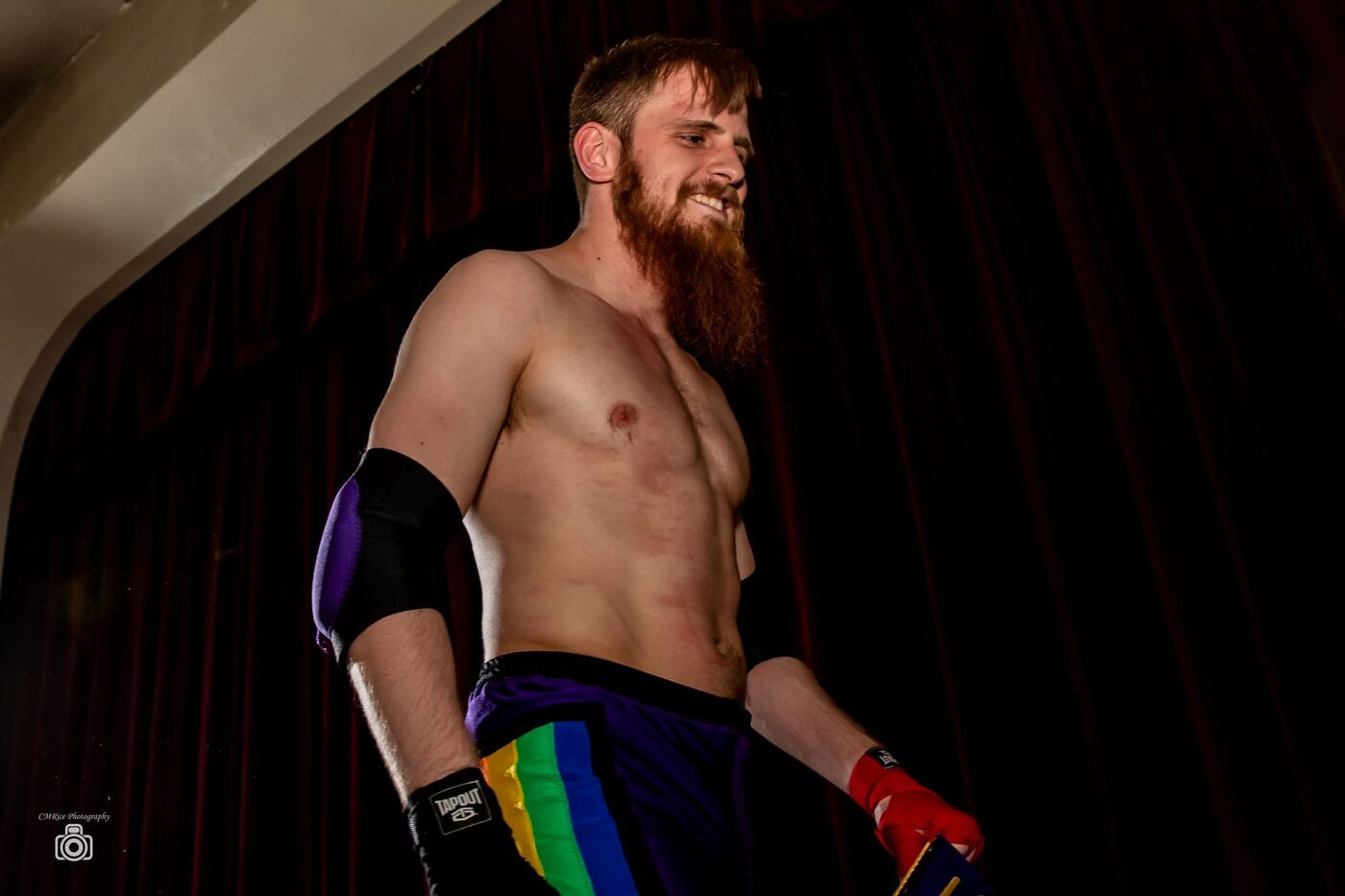 A wrestler stands alone in the ring under a spotlight