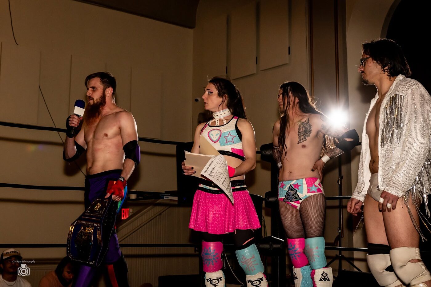 Four wrestlers stand in the ring during a segment
